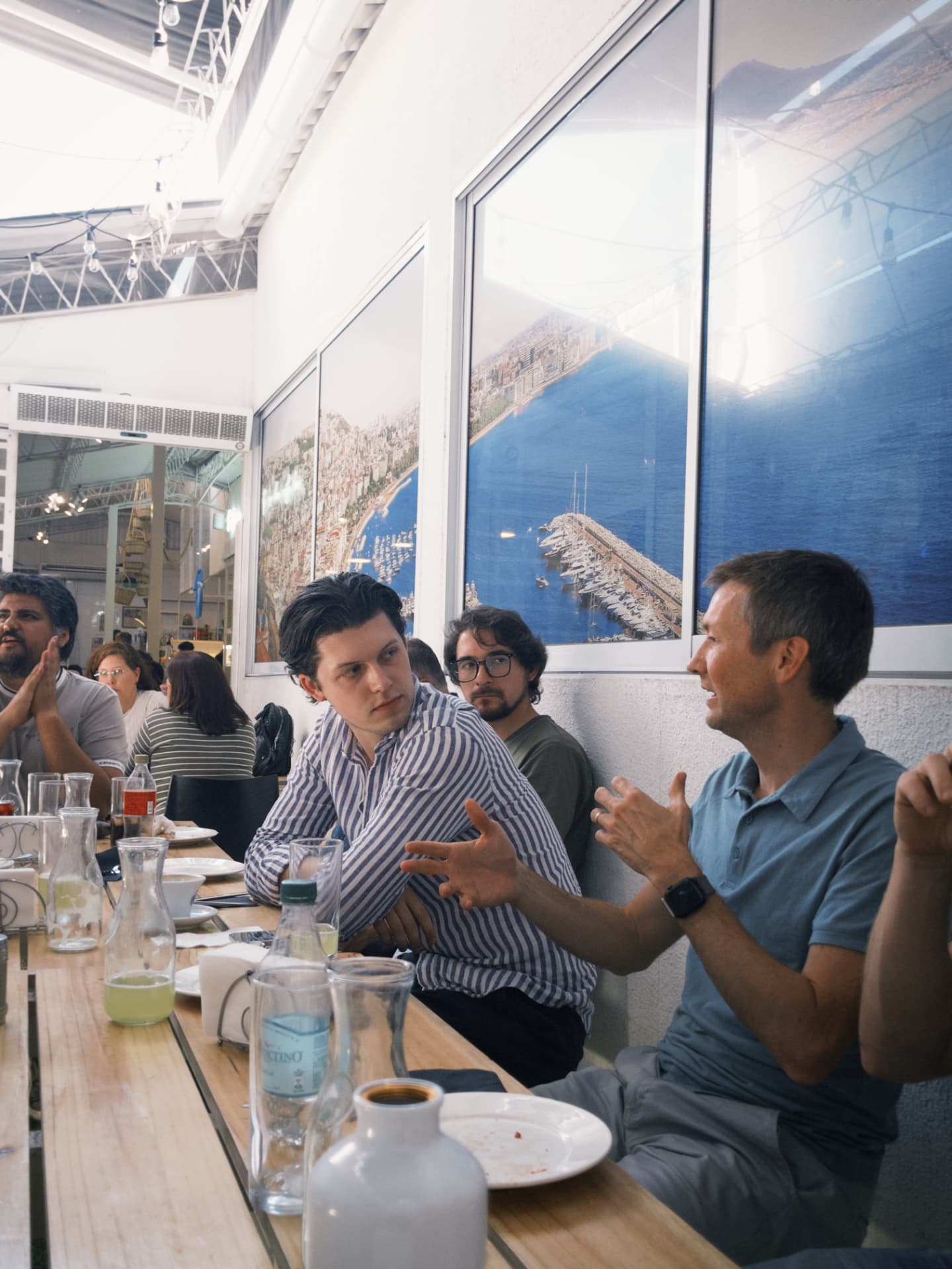 Fellows sharing a group dinner at a long wooden table outdoors